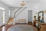 Foyer featuring wood finished floors, crown molding, and stairs