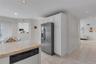 Kitchen featuring a tiled countertop, integrated dishwasher, white cabinetry, and recessed lighting. Access to the two car attached garage.