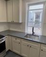 Kitchen with stainless steel gas stove, dark countertops, and plenty of natural light