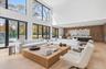 Living room featuring light wood-style flooring, a towering ceiling, and recessed lighting