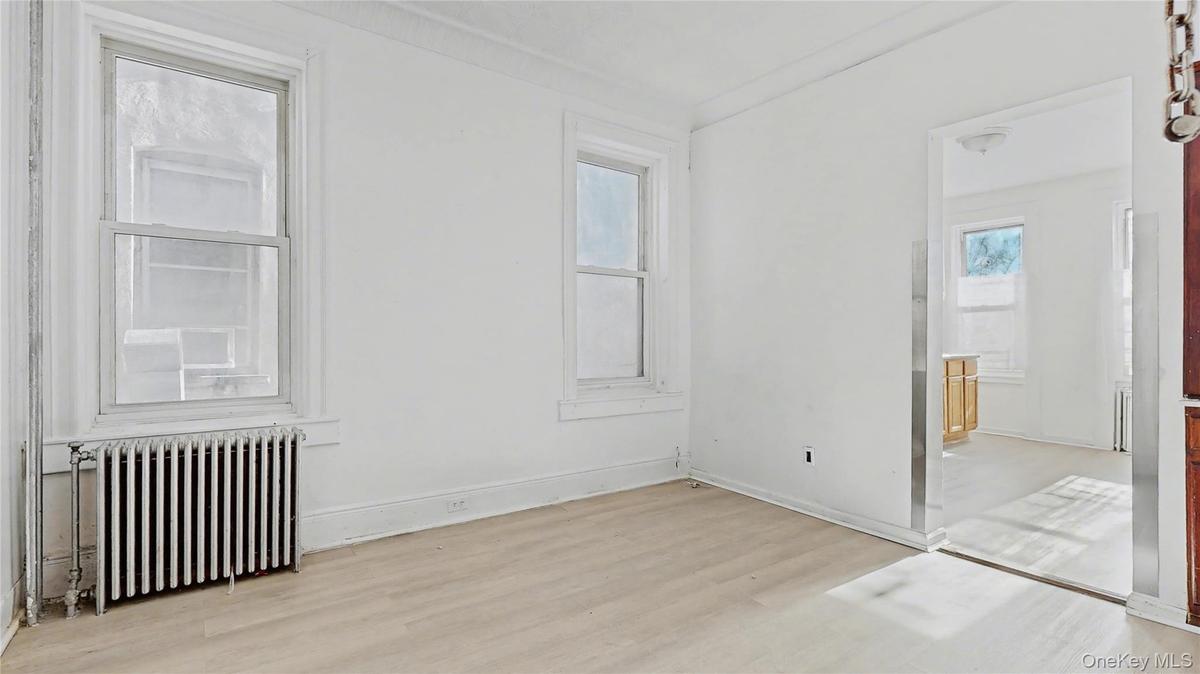 Empty room with radiator and light wood-style flooring