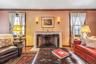 Living area featuring wood finished floors, a premium fireplace, and crown molding