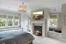 Bedroom featuring carpet flooring, a premium fireplace, and ornamental molding