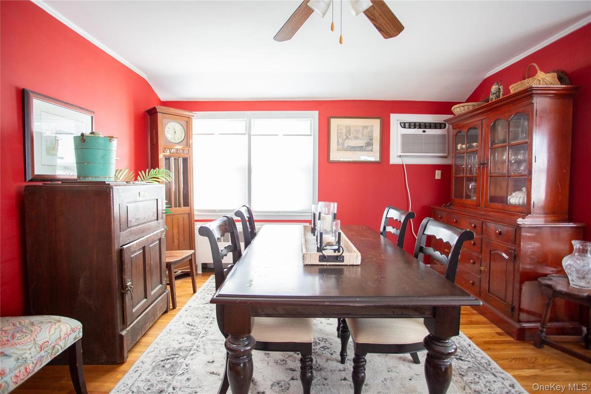 Dining room with light wood-style flooring, a wall unit AC, a ceiling fan, and crown molding