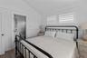 Bedroom featuring vaulted ceiling, dark hardwood / wood-style floors, and ensuite bath