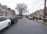 View of asphalt road with a residential view, sidewalks, and curbs