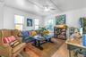 Living room with light wood-style floors, ceiling fan, and ornamental molding