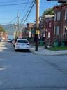 View of asphalt street with street lighting, curbs, sidewalks, and traffic signs