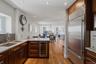 Kitchen featuring wood cabinetry, stainless steel appliances, granite countertops, and hardwood flooring