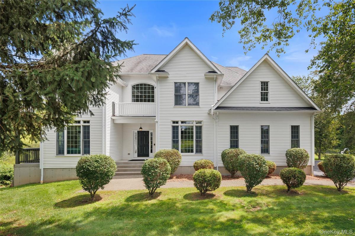 Impressive Colonial-style residence showcasing timeless elegance, exceptional architectural detail, and a grand sense of scale. The classic white exte