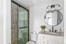 Bathroom featuring vanity, a shower with shower door, and toilet