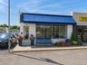Shown with AI-enhanced exterior improvements, including landscaping and awning, to illustrate potential curb appeal.