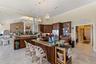 Chef's kitchen flows seamlessly into the grand living room, creating an impressive space for refined living and entertaininmg.