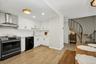 Abundant natural light fills both the kitchen and dining area, while thoughtfully selected decorative lighting adds warmth and character, creating an