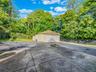 Detached garage featuring view of scattered trees
