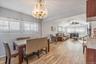 Dining space featuring wood tiled floors, vaulted ceiling, arched walkways, ceiling fan, and suspended lighting