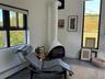 Sitting room with a wood stove, a baseboard heating unit, and tile patterned floors