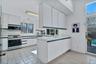 Kitchen featuring stainless steel appliances, visible vents, decorative backsplash, white cabinets and a peninsula