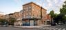 Corner commercial building featuring a brick exterior and ground-floor retail space