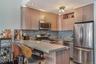 Kitchen with stainless steel appliances, tasteful backsplash, a peninsula, light brown cabinets, and a breakfast bar area