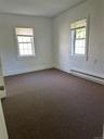 Carpeted empty room with a healthy amount of sunlight and a baseboard radiator