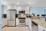 Kitchen featuring white cabinets, a sink, appliances with stainless steel finishes, and tasteful backsplash