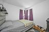 Bedroom featuring wood finished floors and a baseboard heating unit