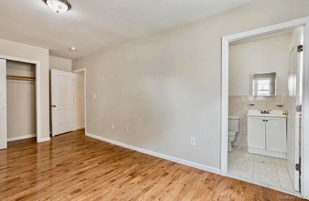 Room featuring wood-finish flooring, light-toned walls, and a ceiling-mounted light fixture