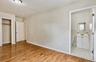 Room featuring wood-finish flooring, light-toned walls, and a ceiling-mounted light fixture