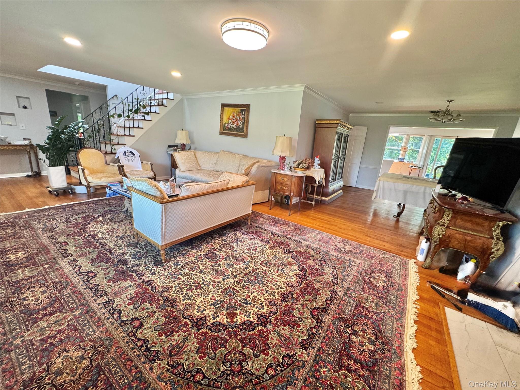 Hardwood flooring throughout, recessed lighting, skylight, and an open stairway with wrought iron balusters