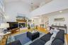 Living area featuring stairway, wood finished floors, a premium fireplace, and high vaulted ceiling