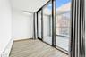 Spare room featuring a baseboard radiator, plenty of natural light, wood finish floors, expansive windows, and a wall mounted AC