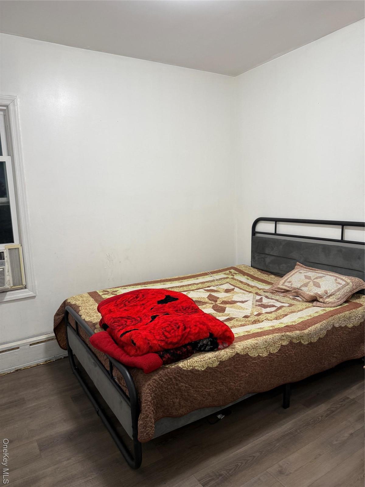 Bedroom featuring baseboard heating and wood finished floors