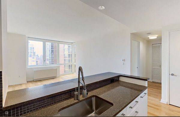Bright one bedroom with oversized corner living room windows, open gourmet kitchen with stainless steel appliances, stone countertops, and eating bar, and an in unit washer dryer.
