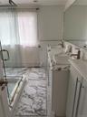 Bathroom featuring wainscoting, a shower stall, vanity, and tile walls