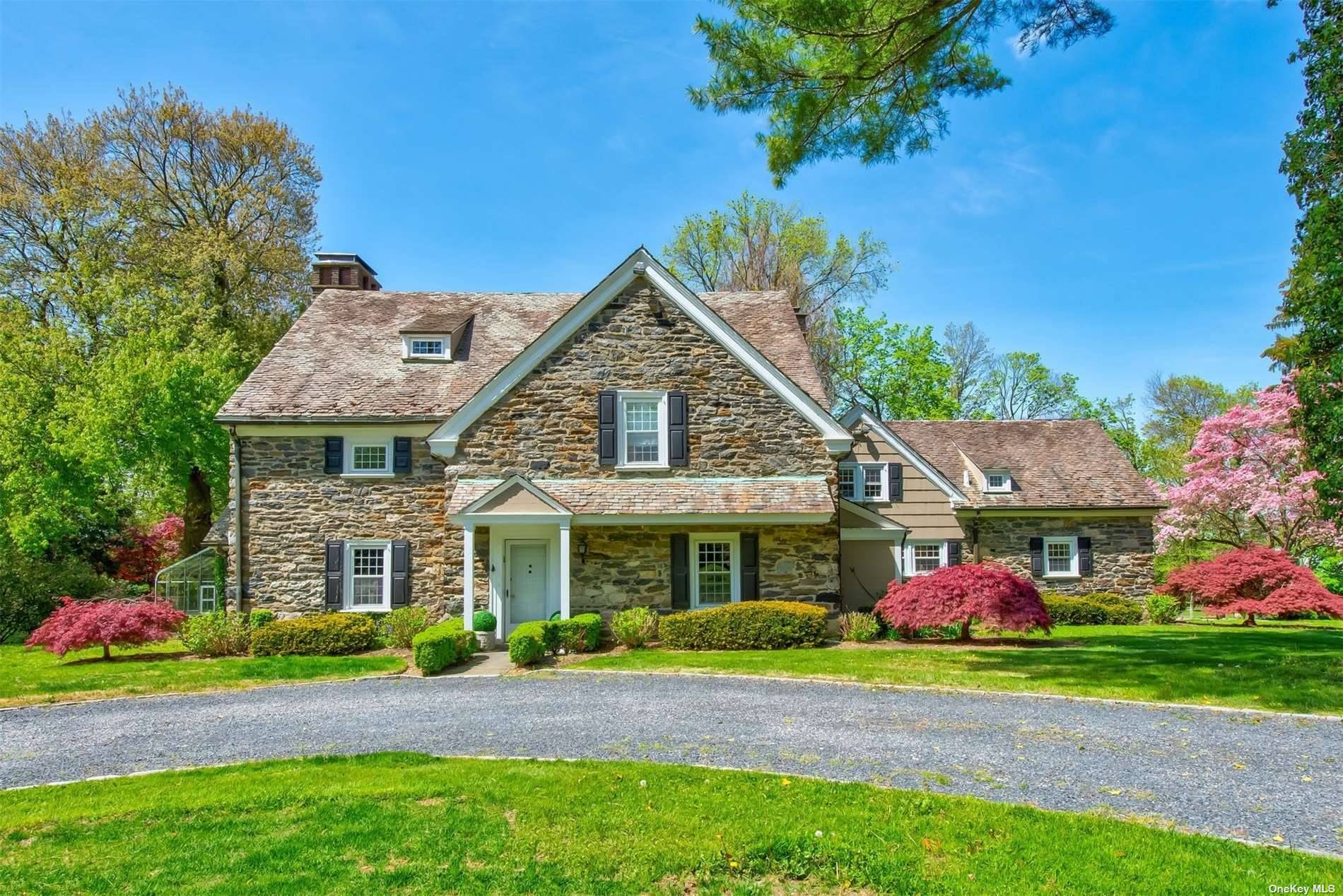 Nestled on over four acres of private lush property with verdant lawns and mature specimen trees in the village of North Hills, this gracious 7 bedroom 4.