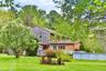 Rear view of property featuring a yard and an outdoor pool