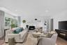 This spacious and bright family room (view from kitchen) has lots of widows ceiling lights on a dimmer, large wall for a Big screen TV with access to
