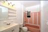 3rd Floor Bathroom featuring tile walls, vanity, washtub / shower combination, and light tile patterned floors