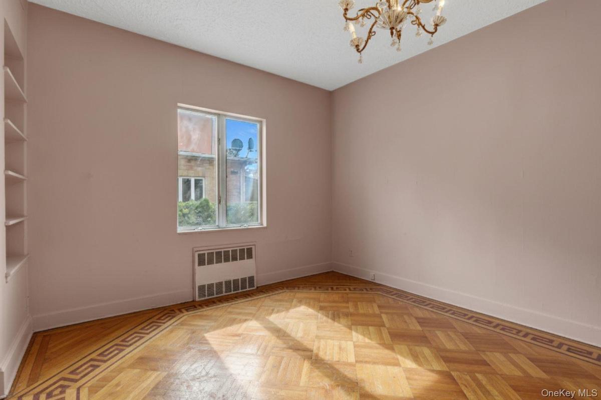 Spare room featuring radiator, a textured ceiling, and a chandelier