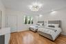 Bedroom with light wood finished floors, a chandelier, and recessed lighting