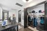 Convenient second-floor laundry closet featuring a full-size washer and dryer, built-in shelving and double doors for easy access. Thoughtfully positi