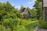 A tranquil garden setting surrounds the wellness studio, creating a peaceful connection with nature