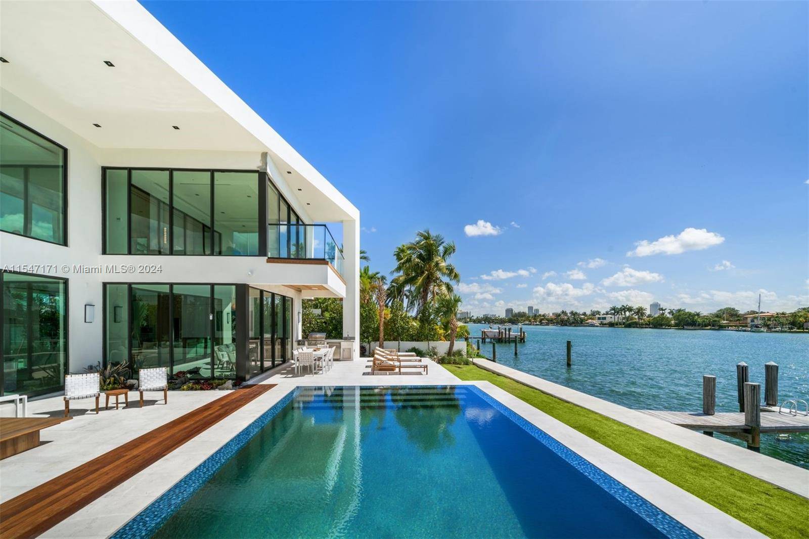 Indulge in opulent waterfront living in this brand new construction home with a premier lot position on the wide bay in gated Biscayne Point.