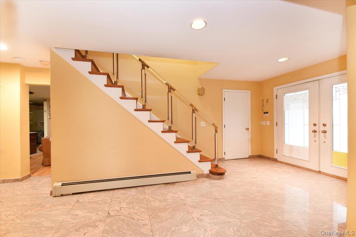 Entryway with a baseboard heating unit and french doors