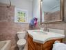 Bathroom featuring vanity, tub / shower combination, wainscoting, and tile walls