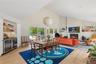 Open-concept living area with wood-finish flooring and a vaulted ceiling