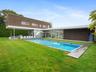 Swimming pool featuring a patio, a lawn, and a sunroom