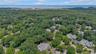 Aerial perspective showcasing a residential community surrounded by abundant mature trees