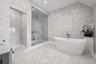 Full bathroom with tile walls, a stall shower, a freestanding bath, vanity, and marble look tiles